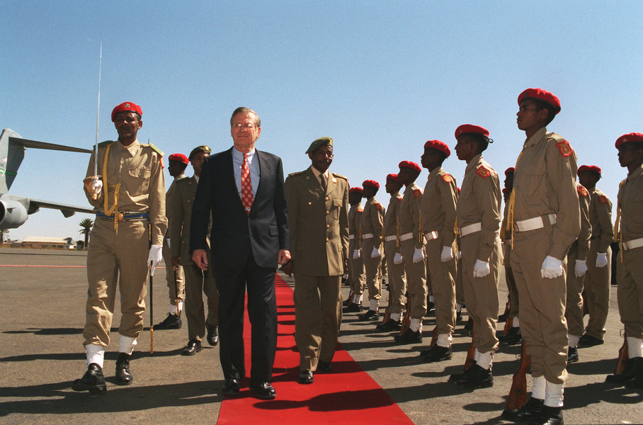 U.S. Defense Secretary Donald H. Rumsfeld (center) and Eritrean Defense Secretary General Sebhat Efrem (right) in a military review during a welcome ceremony, December 10, 2002. Asmara, Eritrea. Photo: Helene C. Stikkel . 