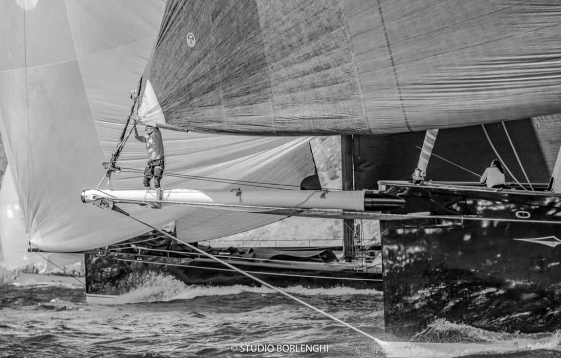Боумен работает на носу Hetairos, крупнейшей лодки флота и победителя регаты St. Barth Bucket 2019. Жаль, что черно-белый снимок не передает удивительный темно-зеленый цвет корпуса этой яхты. На этом кадре Hetairos соревнуется с MySong.