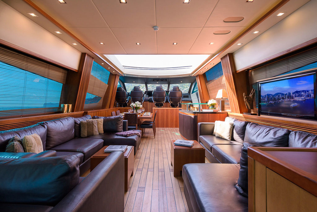 It's not villainous inside the boat at all. The open-plan salon is impressive with its 2.7 meter high ceilings, which is not typical of yachts of this size. Everything is finished in wood and furnished with laconic furniture. Closer to the front, behind the control post, is the dining area (in the film scene, the table serves as an arena for card battles).